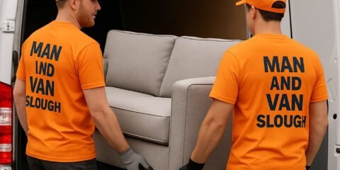 Two Man and Van Slough movers in bright orange shirts loading a sofa into their branded van — professional moving and furniture transport service in Slough.